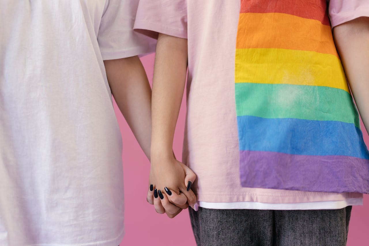 Close-up of two people holding hands, symbolizing love and LGBTQ+ pride.